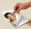 A hand is peeling the backing off a transfer sheet with a picture of a couple on it. Anteprima dell’immagine prodotto