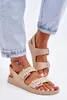 A person's feet wearing beige sandals and light blue jeans. Produktbild-Vorschau