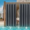 Outdoor curtains hanging on a wooden pergola, with a stone wall and furniture visible in the background. Produktbild-Vorschau