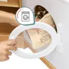 A hand is holding a white oval frame, looking into a cabinet where slippers are stored. An overlay shows a washing machine icon. Podgląd zdjęcia produktu
