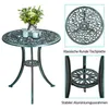 A green metal bistro set with a round table and two chairs, decorated with floral patterns. The table has a vase with flowers and two candle holders on it. The image also includes close-up views of the table top and the base of the table legs, with German  Produktbild-Vorschau