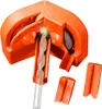 A close-up, angled view of an orange drill bit sharpener with a drill bit inserted, showing sparks flying. Podgląd zdjęcia produktu