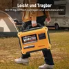 A person is carrying a portable generator outdoors, with a tent and a camper van in the background. Produktbild-Vorschau