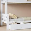 A close-up view of the lower bunk of a white wooden bunk bed, showing a mattress, pillows, and a drawer with toys. Anteprima dell’immagine prodotto