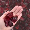Dunkelrote Glasbrocken auf einer Handfläche zur Größendarstellung Produktbild-Vorschau