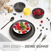 A table setting with breakfast items, including a bowl of cereal with fruit, a glass of orange juice, and cutlery. Anteprima dell’immagine prodotto