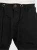A close-up view of the waistband and fly area of black jogging pants. Anteprima dell’immagine prodotto