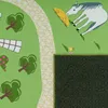 A close-up view of a children's rug with a landscape design, featuring a horse, trees, and a path. Anteprima dell’immagine prodotto