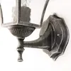 Close-up of a vintage-style outdoor wall lamp mounted on a white wall. Produktbild-Vorschau