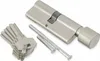 A lock cylinder and keys are laid out on a white background. Produktbild-Vorschau