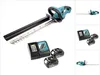 A cordless hedge trimmer with two batteries and a charger, displayed on a white background. Produktbild-Vorschau