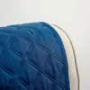 Close-up of a quilted blue sofa cover with a beige edge. Produktbild-Vorschau