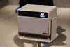 A projector sits on a stand. Náhľad obrázku produktu