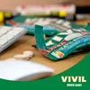 A VIVIL product package is open on a wooden desk next to a computer keyboard and mouse, with some lozenges scattered nearby. Produktbild-Vorschau