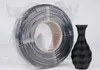 A roll of black 3D printer filament is shown next to a black 3D printed vase. Náhled obrázku produktu