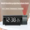 A digital projection alarm clock is displayed on a white surface, with a red projection beam visible. Podgląd zdjęcia produktu