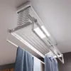 A ceiling-mounted automatic clothes drying rack with towels and a shirt hanging on it. Produktbild-Vorschau