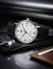 A watch and cufflinks are laid out on a dark surface. Voir les images du produit