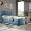 A bedroom scene with a blue upholstered bed, a window with a view of trees, and a rug on the floor. Produktbild-Vorschau