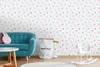 A child's room with a teal sofa, a white rocking horse, and storage bags against a polka-dotted wallpaper. Produktbild-Vorschau