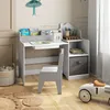 A child's desk and chair set in a room with decorative wallpaper and a toy car. Podgląd zdjęcia produktu