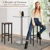 A woman sits on a bar stool next to a high table, with another bar stool beside it. Podgląd zdjęcia produktu
