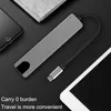 A USB-C hub is shown next to a smartphone and a tablet, with text indicating it's convenient for travel. Produktbild-Vorschau