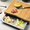 A bamboo cutting board with a built-in stainless steel drawer containing chopped fruit and peels. Anteprima dell’immagine prodotto