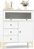 A white cabinet with a fluted glass door and gold legs, decorated with vases, books, and a small floral arrangement on top. Produktbild-Vorschau
