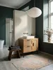 Der Badschrank mit Schubladen und Tür aus Rattan steht neben einer freistehenden Badewanne und schafft eine organisch-moderne Badezimmereinrichtung._#sku_SAFWL6.876# Produktbild-Vorschau