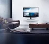 A modern living room with a sofa, coffee table, and a TV mounted on the wall. Voir les images du produit