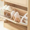 A close-up view of a wooden shoe cabinet with shoes on its shelves. Náhľad obrázku produktu