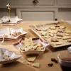 Christmas cookies on a wooden table with festive serving dishes and a glass of red wine. Produktbild-Vorschau