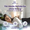 A woman sleeping peacefully on a bed with a duvet. Produktbild-Vorschau