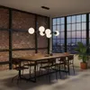 A modern dining room with a brick wall, large windows overlooking a city skyline, and a wooden dining table with chairs. Produktbild-Vorschau