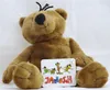 A brown teddy bear sitting down with a tag in front of it. Produktbild-Vorschau