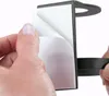 A hand peeling the adhesive backing off a black soap dispenser. Produktbild-Vorschau
