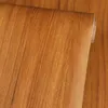 A close-up view of a roll of wood-patterned adhesive vinyl. Anteprima dell’immagine prodotto