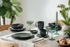 A dining table set for a meal with plates, cups, and decorative elements. Produktbild-Vorschau