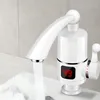 A close-up shot of a white electric water heater faucet with a digital display showing the temperature. Náhled obrázku produktu
