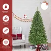 A Christmas tree is set up in a room with a chair and decorations. Produktbild-Vorschau