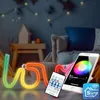 A neon LED sign spelling 'LOVE' is displayed in a child's bedroom, with a smartphone and remote control nearby. Anteprima dell’immagine prodotto
