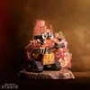 A Wall-E figurine is displayed on a rocky base with a backdrop of a post-apocalyptic city. Anteprima dell’immagine prodotto