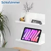 Two white shelves mounted on a white wall, one holding a vase with branches, a wooden toy, and a digital clock, the other holding a tablet. Voir les images du produit