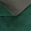 A close-up view of the underside and edge of a dark green rug, showing the anti-slip backing. Produktbild-Vorschau