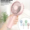 A hand holding a pink mini fan, with a plant in the background and a collage of other colored mini fans in the bottom right corner. Produktbild-Vorschau