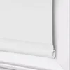 A close-up view of a white roller blind installed in a window frame. Produktbild-Vorschau