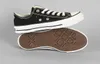 A pair of black Converse All Star low-top sneakers are shown against a plain gray background. One shoe is placed on top of the other, with the sole of the bottom shoe facing upwards. Voir les images du produit