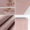 A collage of images showing a pink rug from different angles, including close-ups of its texture and edges, and a hand touching it. Produktbild-Vorschau