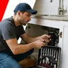 A plumber working under a sink with a toolbox. Podgląd zdjęcia produktu